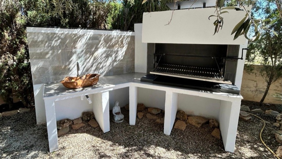 Barbacoa de obra con parrilla y encimera exterior