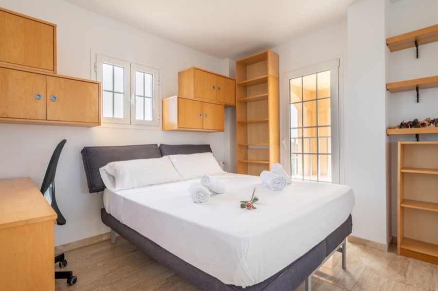 Dormitorio con cama doble y mesa de trabajo